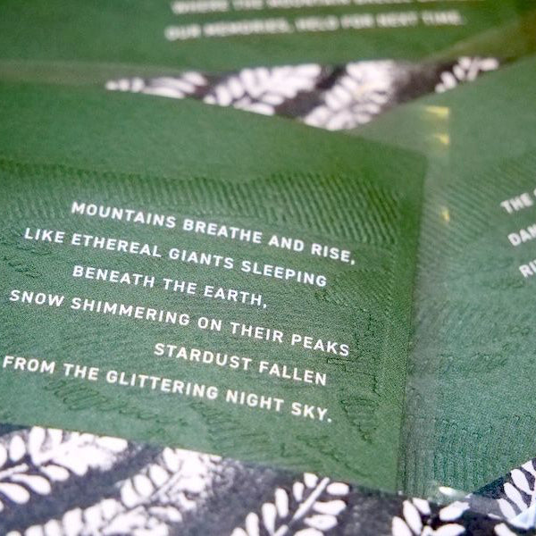 poem about New Zealand mountains on a textured surface with floral patterns