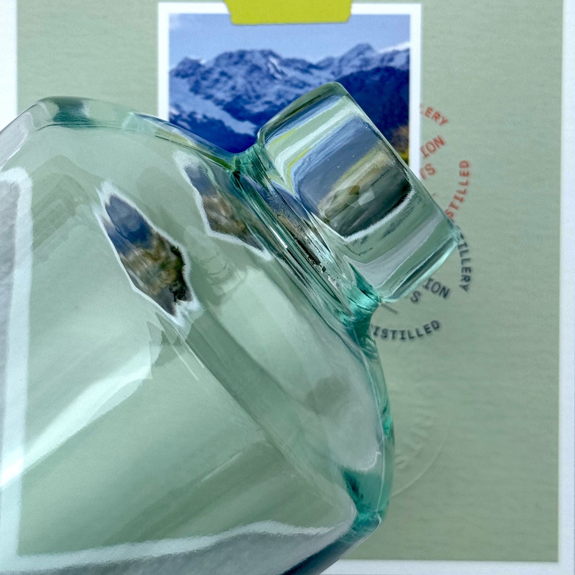 Green glass bottle with mountain landscape in the background